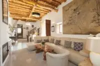 Can Frare Living Room showing large cream sofa, coffee table, armchair, wooden ceiling beams