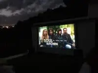 Outdoor cinema Ibiza we see soul kitchen on the tv screen and it is night time
