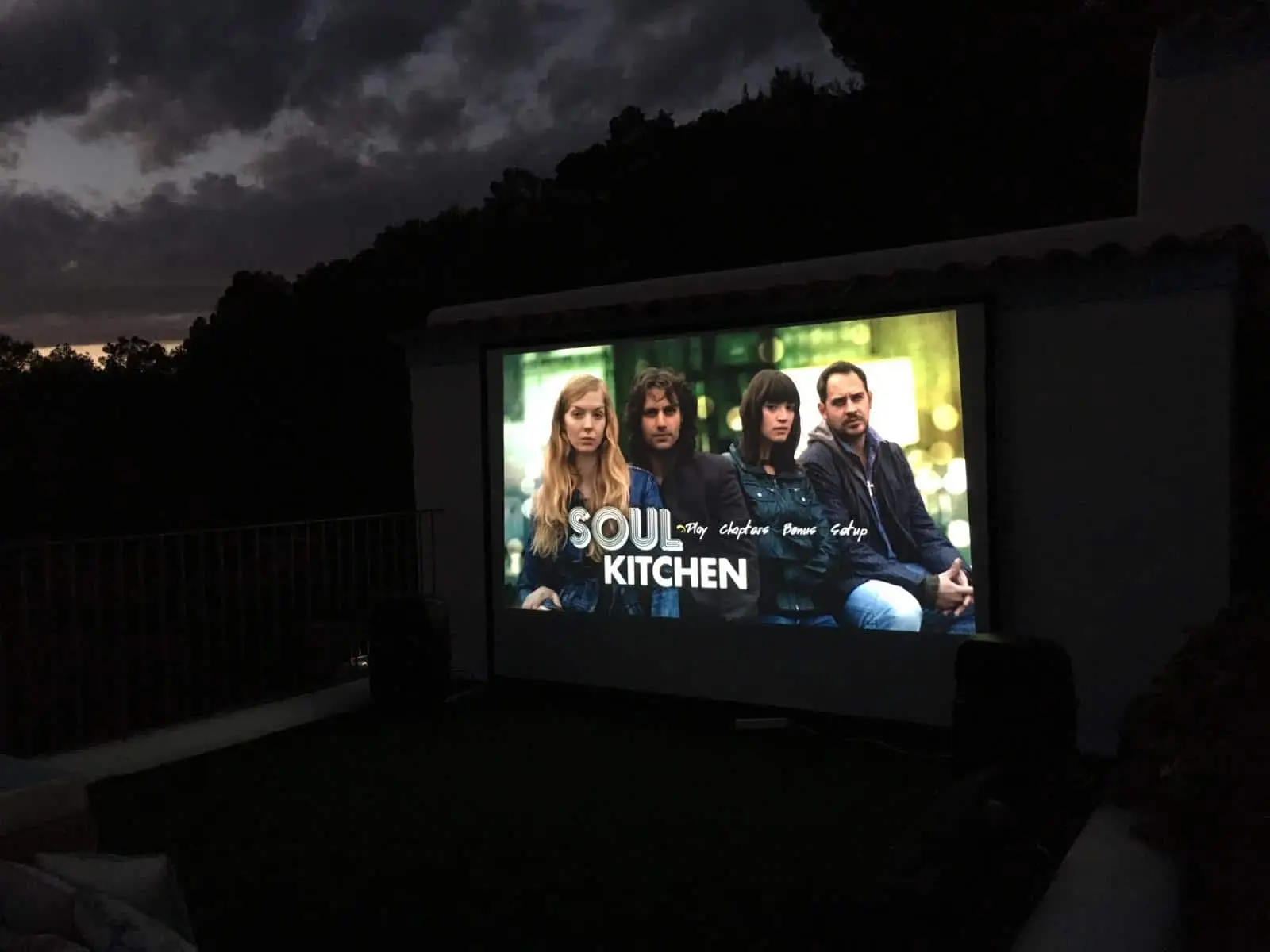 Outdoor cinema Ibiza we see soul kitchen on the tv screen and it is night time