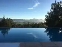 Can Frare Ibiza infinity pool in winter against backdrop of hills in the distance