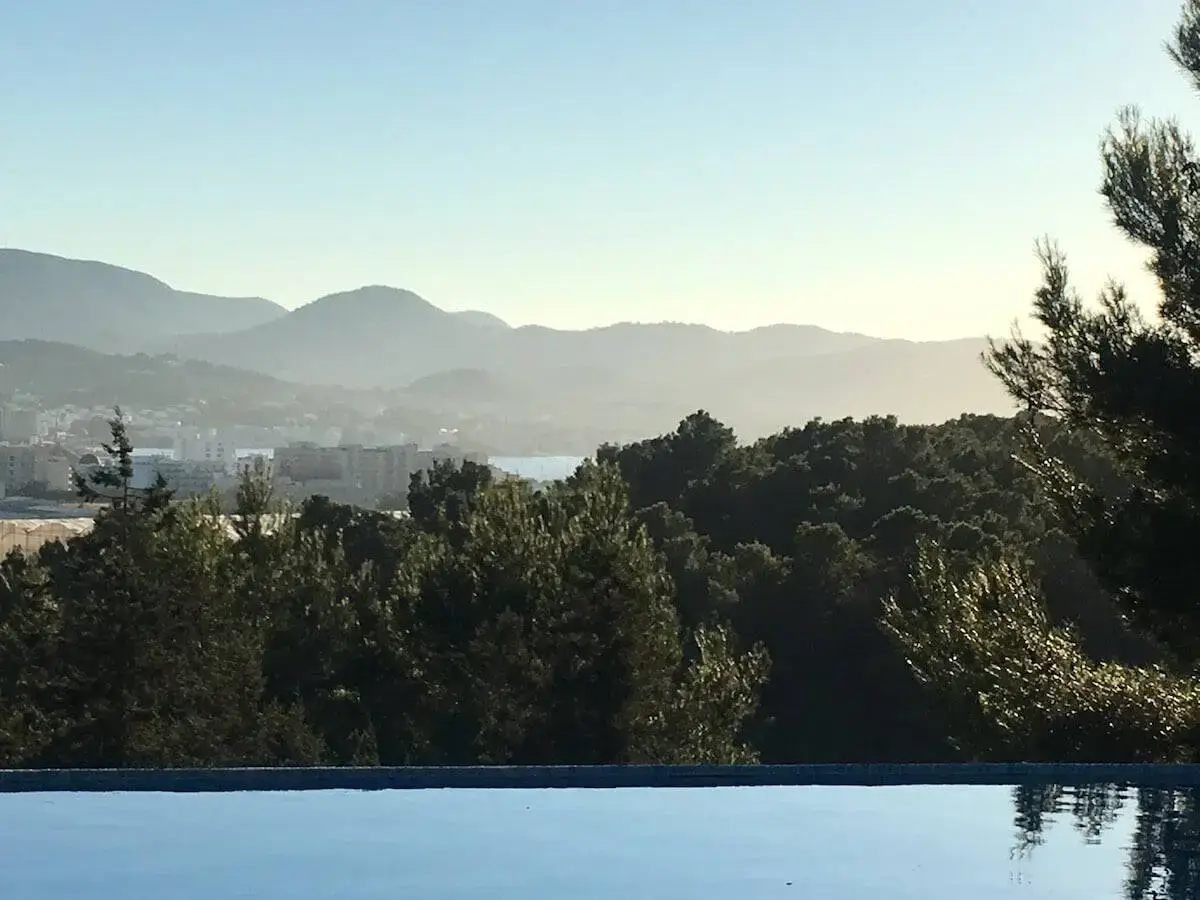 Can Frare Ibiza winter view of infinity swimming pool and hills in the distance