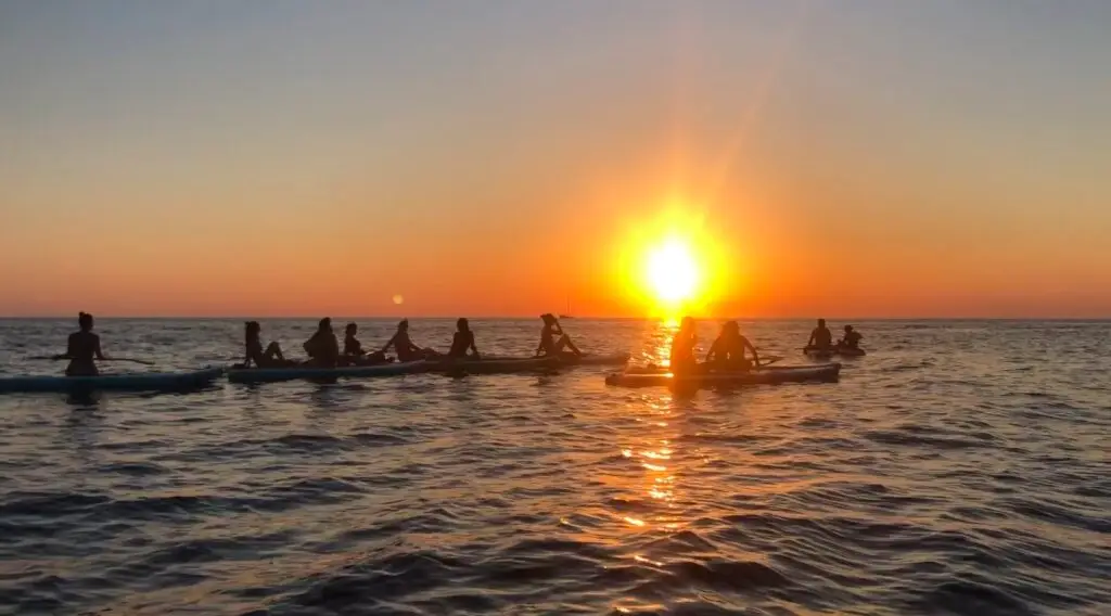 Ibiza SUP experience with sunset showing paddle board group in evening glow from the sunset