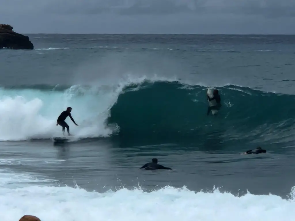 surfers in sea enjoying surfing in ibiza with rolling waves