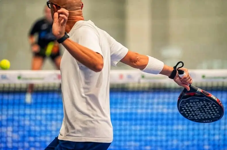 Ibiza Padel Indoor Club with Modern Facilities showing bald man serving in sports clothing