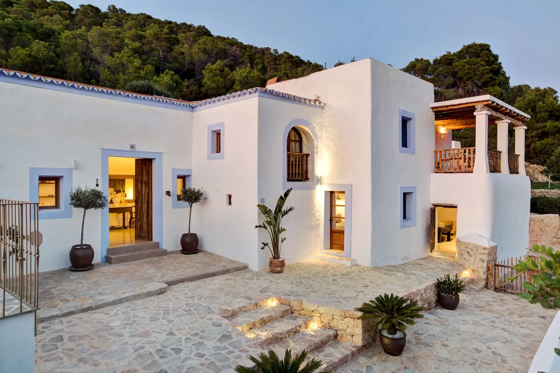 Can frare ibiza white washed walls, blue surround painted windows, stone patio in early evening light