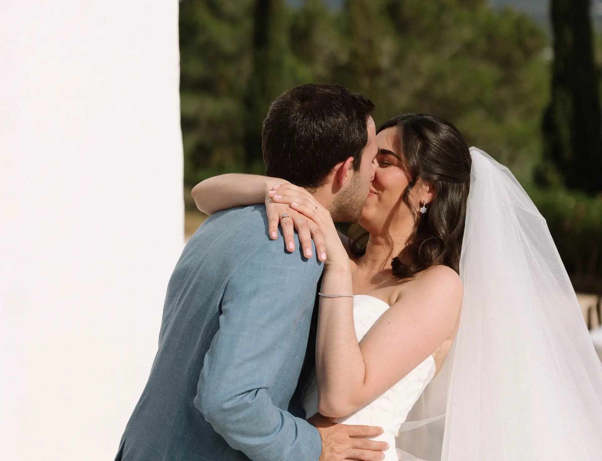 Martina and Joan’s Wedding Celebration at Can Frare Ibiza showing the newly married couple embrace in a passionate kiss